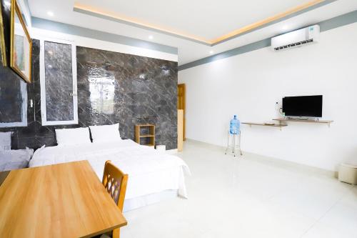 Nhơn TrạchHotel Trâm Anh的一间卧室配有两张床、一张桌子和一台电视。