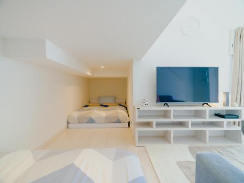 熊本YOUR ROOM Kumamoto Sta little 103 Vacation STAY 75704的白色的客厅配有电视和床。
