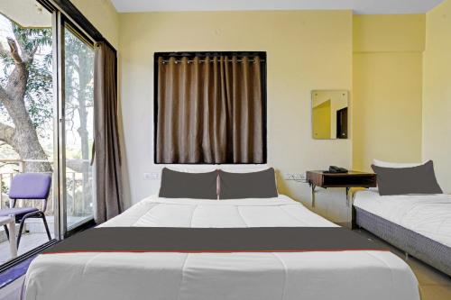 罗纳瓦拉Collection O Dream Majestic的一间卧室设有两张床和窗户。