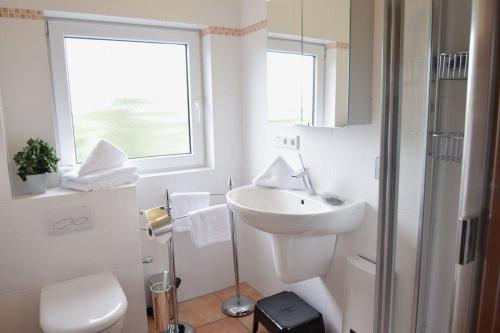 文尼斯塔特3-Zimmer Appartement in Wenningstedt in ruhiger Lage的白色的浴室设有水槽和淋浴。