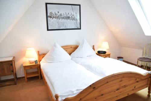 文尼斯塔特3-Zimmer Appartement in Wenningstedt in ruhiger Lage的一间卧室配有一张带白色床单和两盏灯的床。