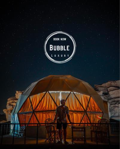瓦迪拉姆Wadi rum Bubble luxury camp的站在大帐篷前的人