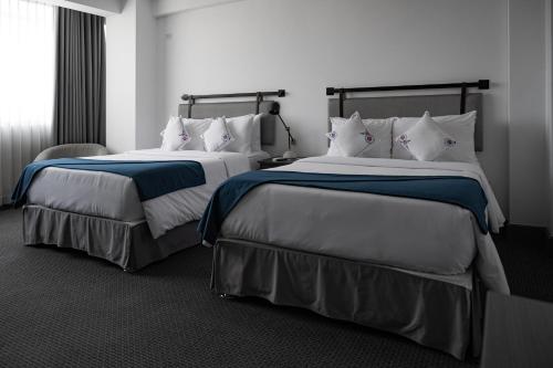 阿雷基帕QASA by NOMAD的酒店客房,配有两张床和椅子