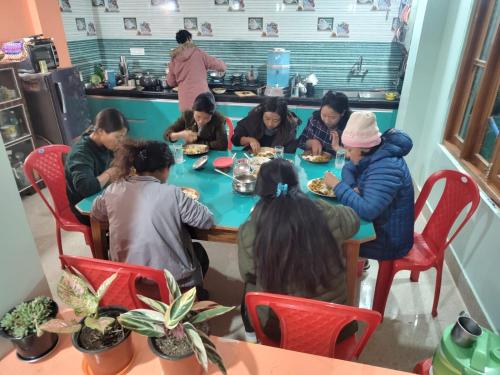 NamchiBarbet Homestay Kitam的一群坐在桌子旁吃食物的人