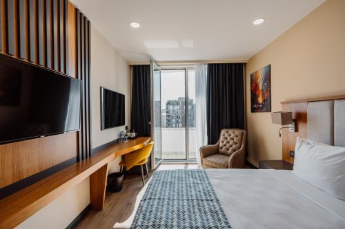 巴统Best Western Plus Batumi的酒店客房配有一张床、一张书桌和一台电视。