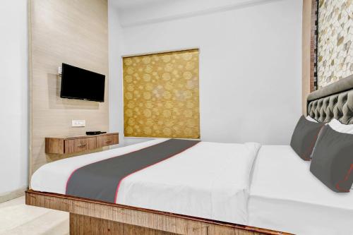 印多尔OYO Hotel Evanka的卧室配有白色的床和电视。