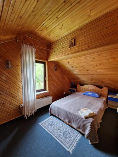 古拉哈莫卢洛伊Voro Mold的木制客房内的一间卧室,配有一张床