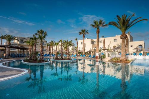 赫索尼索斯Europa Beach Hotel & Spa的度假村内一座种有棕榈树的大型游泳池