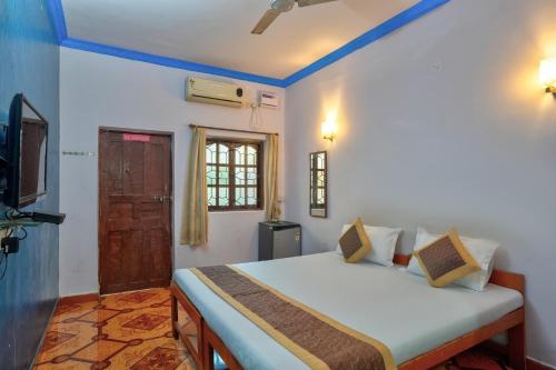 巴加Baga Beach Walk的一间卧室配有一张床,并在一间客房内配有电视。