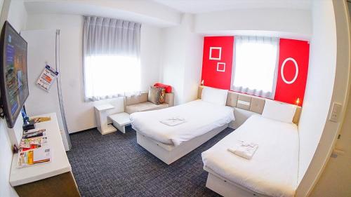 东京Henn na Hotel Tokyo Ginza的一间小房间,配有两张床和一张沙发