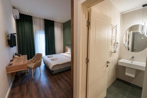 库塔伊西Central Hotel Kutaisi的一间卧室配有一张床、一张桌子和一个水槽