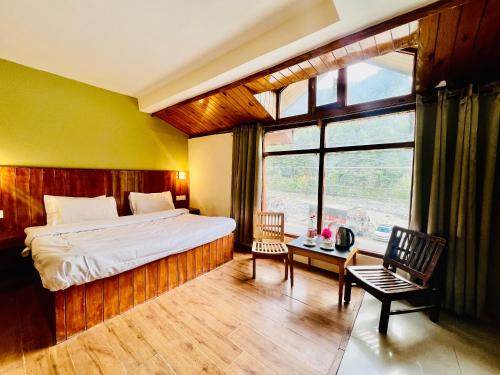 马拉里Hotel Sliver Inn - Affordable Luxury Stay Near Mall Road的一间卧室设有一张床和一个大窗户