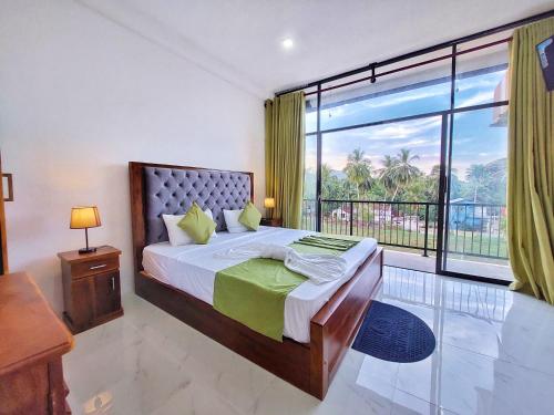 丹不拉Catch Up Dambulla的一间卧室设有一张床和一个大窗户
