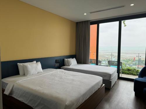 清化Flamingo Hải Tiến的酒店客房设有两张床和大窗户。