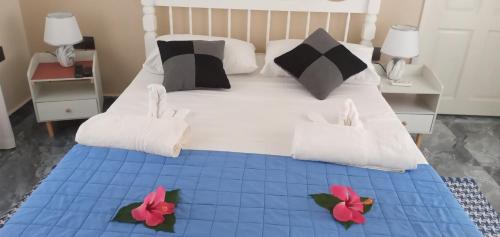 拉迪格岛丹卡佐自助式度假屋的一间卧室配有一张大床,床上有两朵鲜花