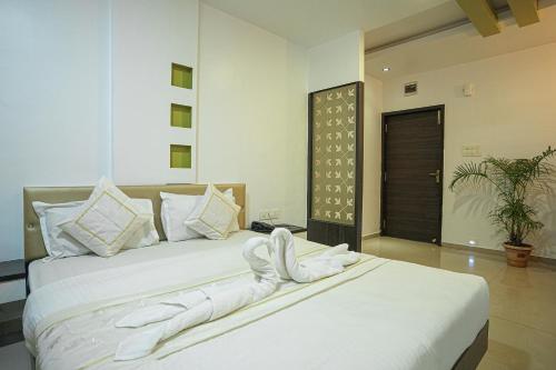 拉特纳吉里HOTEL ANAND的一间卧室配有两张带毛巾的床