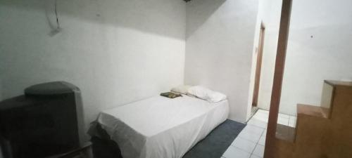 万隆SPOT ON 93964 Guest House Pak Gatot 3的一间白色的小房间,配有床和电视