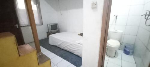 万隆SPOT ON 93964 Guest House Pak Gatot 3的一间小卧室,配有一张床和一个卫生间