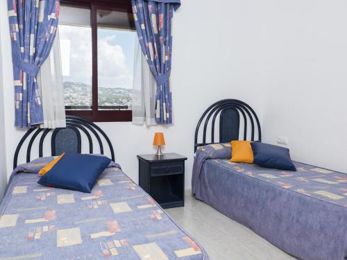 卡尔佩Apartamentos Coral Beach Unitursa的一间卧室设有两张床和窗户。