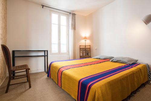 昂古莱姆Centre-ville, rempart sud的卧室配有床、椅子和窗户。