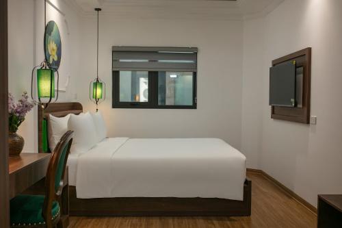 河内Eliana Premio Hotel Hanoi的一间卧室配有一张床、一张书桌和一台电视。