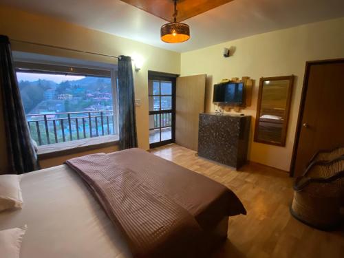穆克缇斯瓦Khushi Cottage的一间卧室设有一张床和一个大窗户