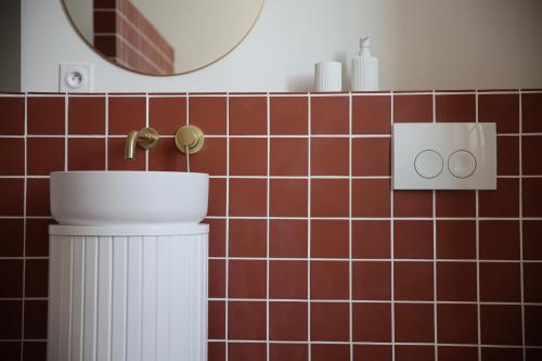 ParmainLomalia的浴室设有卫生间、镜子和红色瓷砖