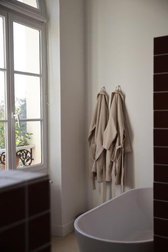 ParmainLomalia的带浴缸的白色浴室和窗户。