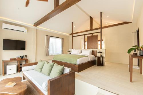 格兰岛Malaya Villa Kohlarn的一间卧室配有一张床和一个沙发