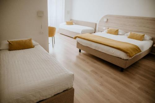 特伦托威尼斯酒店的酒店客房,设有两张床和一张沙发