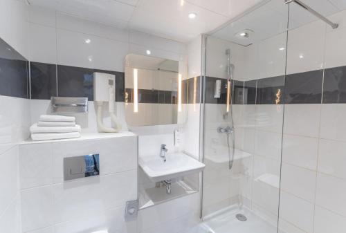 巴黎Hotel Inn Design Paris Place d’Italie (ex Timhotel)的白色的浴室设有水槽和淋浴。