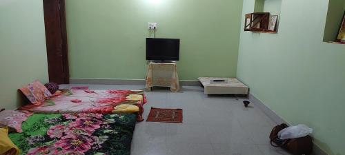 德奥加尔Anand Bhavan的客房设有一张床和一台平面电视。