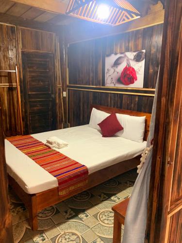 Làng BangPuluong Bao Gia Homestay的木墙客房内的小床