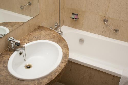 巴塞罗那阿伯特酒店的浴室配有白色水槽和浴缸。
