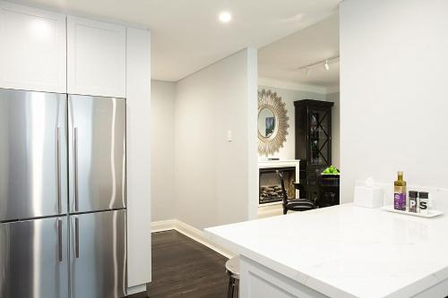 悉尼Bayside Retreat的厨房配有白色橱柜和冰箱。