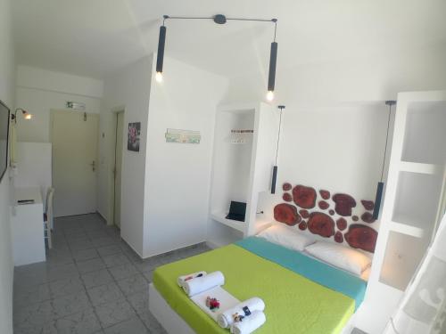 伊奥斯乔拉Nikolas ios Village的白色客房,配有一张带绿色和白色床的床铺,面积达2平方米。