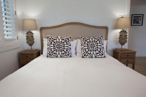 悉尼Villa Bianca Clovelly的卧室配有白色的床和2个枕头
