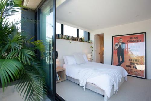 悉尼The Treehouse Penthouse的卧室设有白色的床和大窗户