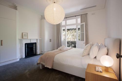 悉尼The Timeless Modern Glebe的白色卧室配有一张大床和吊灯