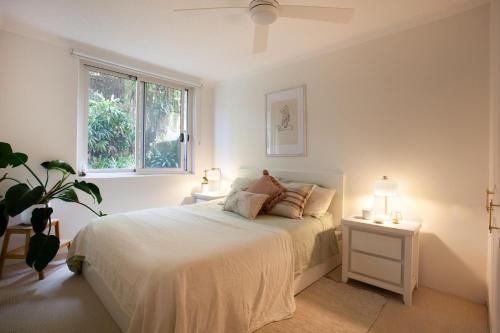 悉尼La Brisa Coogee的一间白色卧室,配有一张床和两盏灯