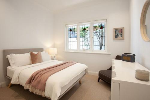 悉尼The Cali Beach house Bronte的白色的卧室设有床和窗户