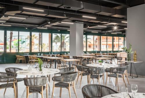 滨海罗克塔斯ALEGRIA Colonial Mar的餐厅设有桌椅和窗户。