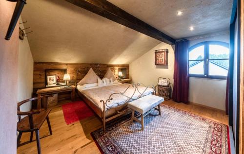 米滕瓦尔德Romantische 5-Sterne- Ferienwohnungen的一间卧室配有一张床、一张桌子和一个窗户。