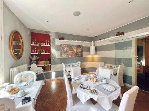 坎诺比奥卡萨阿瑞泽欧酒店的用餐室配有白色的桌子和白色的椅子