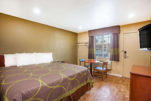 雷德兰兹雷德兰兹速8酒店的酒店客房设有床、桌子和电视。