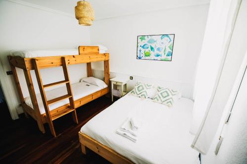 洛雷多Loredo Surf House的一间卧室设有两张双层床和梯子