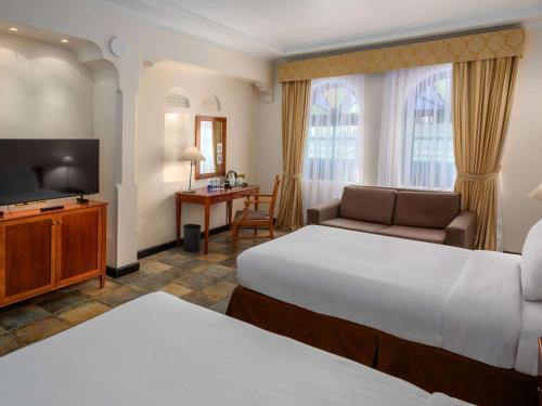麦纳麦巴林铝达纳度假村诺富特酒店的酒店客房设有两张床和一台平面电视。