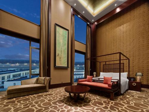 顺义北京首都机场希尔顿酒店的一间卧室配有一张床、一张沙发和窗户。