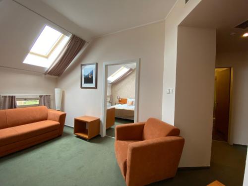 佩奇索皮阿娜精品酒店的一间带橙色家具的客厅和一间卧室