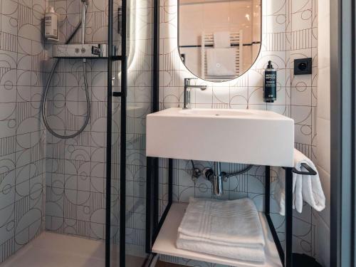 沙勒罗瓦Aero44 Hotel Charleroi Airport的一间带水槽和镜子的浴室